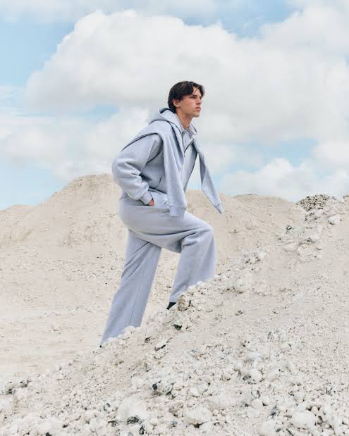 Model wearing light grey Pangaia clothing in a pale outdoor landscape